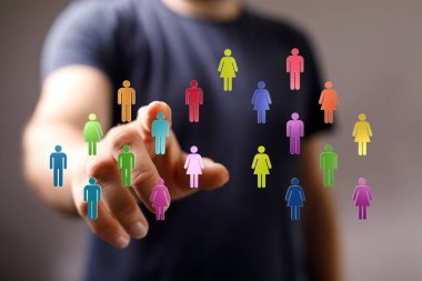 Dijital avatarları işaret eden kişinin eli, takım çalışması kavramı