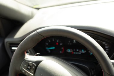 Kırmızı dikişli siyah deri bir direksiyon.