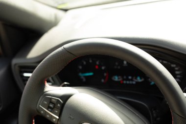 Kırmızı dikişli siyah deri bir direksiyon.