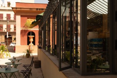 Cam cepheli ve bahçe mobilyalı bir açık hava kafe.