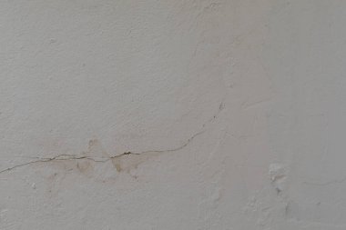 İnce bir çatlak pürüzsüz beyaz duvarın içinden geçiyor.