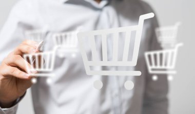 Çevrimiçi alışveriş için sanal ekranda alışveriş arabası simgeleri çizen kişi