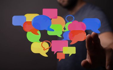 Elin renkli konuşma baloncuklarıyla etkileşimi iletişim konseptini gösteriyor