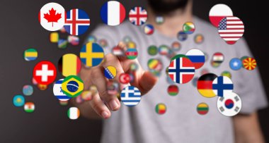 Global Bağlantılar: İnsan eli uluslararası ilişkileri temsil eden çeşitli ülke bayraklarıyla etkileşim halinde