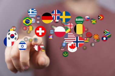 Dünya ülkelerini temsil eden küresel bayrakları seçen insan eli