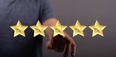 Adamın eli beş altın yıldızı işaret ediyor, değerlendirme konsepti