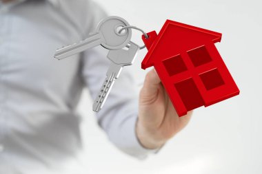 Emlakçı evin anahtarlarını tutuyor.