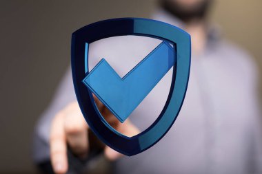 Kalkan sembolüne dokunan adam veri güvenliği kavramını ve güvenceyi temsil ediyor.