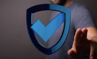 İşaretli mavi kalkana dokunan adam, iş koruma konsepti