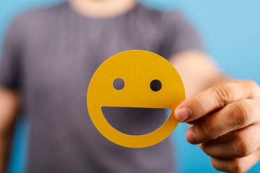 Mavi Arkaplanda Gülümseyen Yüz Emojisi Tutmak