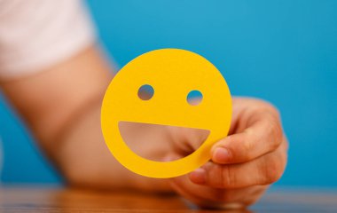 Mavi Arkaplanda Sarı Gülen Yüz Tutmak