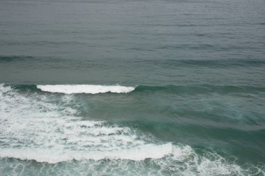 Okyanus önünüzde uzanır. Derin mavi bir tuval ve bir lin ile.