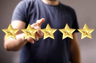 İnsanın eli beş altın yıldızı işaret ediyor. Reytingleri ve kaliteyi simgeliyor.