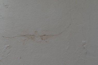 Çatlak bir duvarda aşınma ve yırtık izleri var.