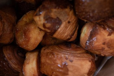 Sıcak, altın sarısı çörekler üst üste yığılmış. Tatlı ikramlar, pastane, kahvaltı