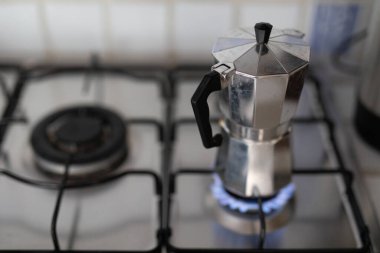 Gümüş bir kahve demliği soba ocağında demleniyor.