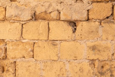 Yıpranmış tuğladan bir duvar ve kayıp havan.