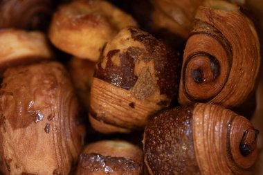 Kruvasan ve çikolatalı acı da dahil olmak üzere çeşitli yeni pişmiş hamur işlerinin yakın çekimi..