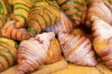 Şam fıstıklı ve kırmızı kadife aromalı zanaatkar kruvasanları, taze pişmiş ve lezzetli..