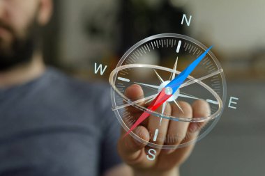 Elinde şeffaf bir pusula tutan adam doğru yönü gösteriyor.