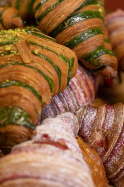 Fıstıklı ve kırmızı kadife aromalı çeşitli kruvasanlardan yakın çekim. Fırın, yemek blogu ya da kafe için mükemmel..