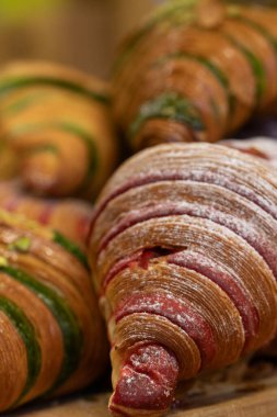 Kırmızı kadife ve şam fıstığı aromalı taze kruvasan yakın plan. Tatlı pasta..