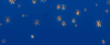 Mavi gökyüzüne düşen altın ve beyaz kar tanelerinin soyut görüntüsü. Kış sihri ve sükuneti çağrıştırıyor..