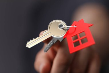 Ev anahtarlarıyla kırmızı ev anahtarlığı, emlak konsepti.