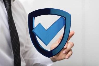 İşadamı el işaretli mavi bir kalkanı işaret ediyor, güvenlik kavramı..