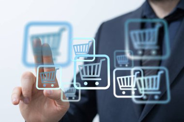 Alışveriş arabası simgelerine dokunan adam, çevrimiçi perakende ve e-ticareti temsil ediyor..