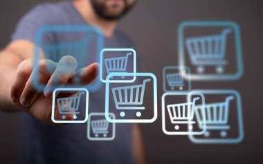 Çevrimiçi alışveriş konsepti. El arabası simgelerine dokunan kişi.