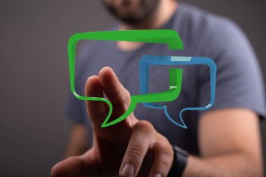 İletişim baloncuklarına dokunan, diyaloğu ve sohbeti temsil eden adam..