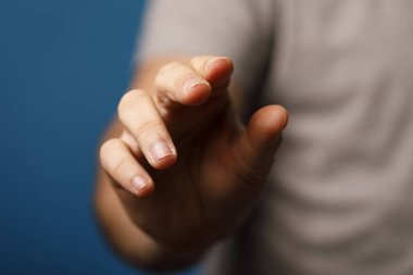 İnsan eli mavi arkaplanı işaret eder ya da dokunur, yakın plan konsepti