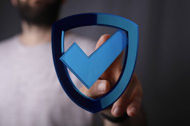 Adam dijital kalkana işaretle dokunuyor, koruma ve güvenliği simgeliyor..