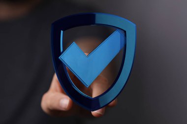 Üzerinde işaret olan bir kalkan, koruma ve güvenliğin sembolü.