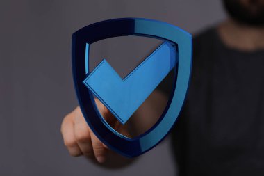 İşaretli Sembollü Mavi Kalkan Tutan Kişi: Güvenlik Konsepti