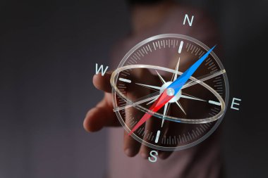Yönlendirme ve yönlendirme için pusulayı gösteren bir elin yakın çekimi