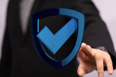 İş adamı el, güvenlik için mavi işaretli kalkan simgesine işaret ediyor