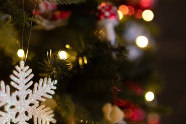 Işıklı Noel ağacında ışıldayan kar tanesi süsü