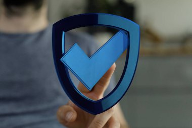 Mavi bir kalkanı işaret eden bir adam, güvenlik konsepti.