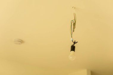 Tavandan sarkan bitmemiş lamba armatürü.