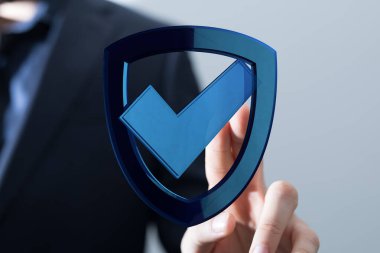 Güvenlik, güvence ve başarıyı sembolize eden kalkan ve kontrol işaretli veri koruma kavramı