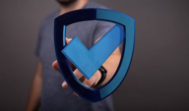 Üzerinde işaret işareti olan mavi bir kalkan tutan adam güvenlik, koruma ve onayı temsil ediyor.