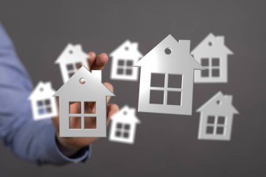 Bir insanın elinde yüzen evlerin kavramsal tasviri, rüya evi