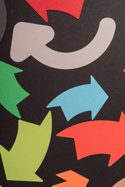 Siyah arkaplan üzerinde renkli oklar kağıt kesikleri yön ve kavramları önerir