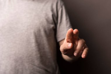 Adam odaklanmış ve beklenen bir şeyi işaret ediyor.