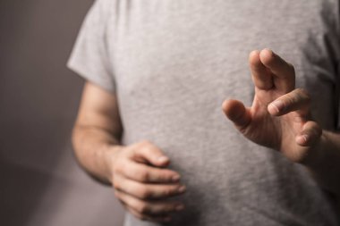 Elleri yakın hareket eden, soyut düşünceler taşıyan bir adam.