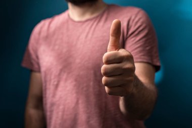 Mavi arka planda onaylanmış bir jest yapan adam