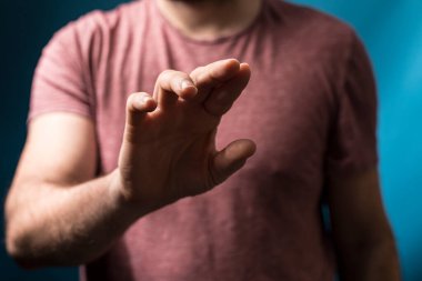 Adamın eli, duyguları ifade eden hareketler, bulanık arka planda yakın çekim.