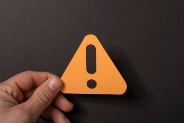 Siyah arka planda turuncu uyarı işareti var. Uyarı konsepti